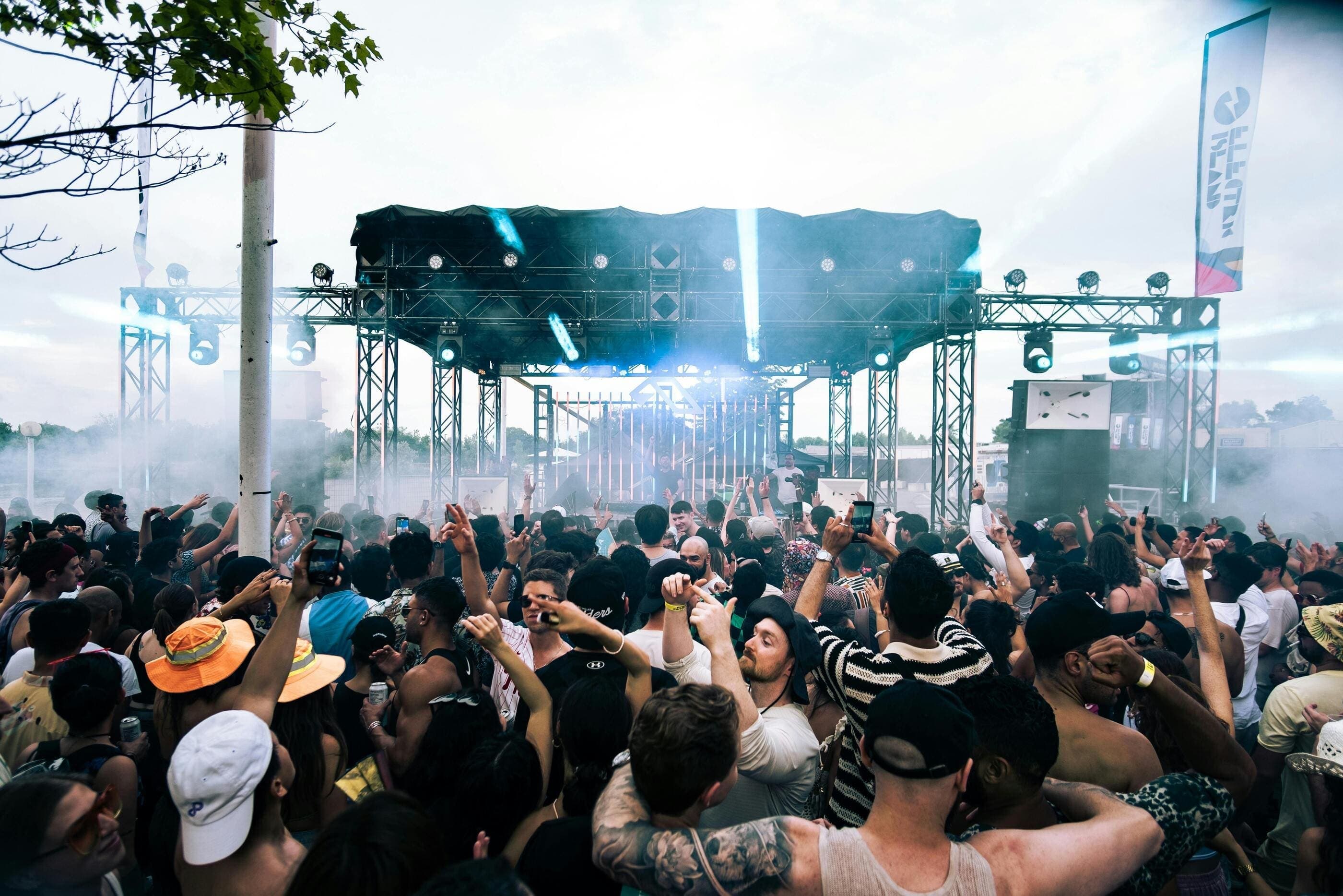 Crowd dancing at electronic music festival DJ stage house vs techno music atmosphere